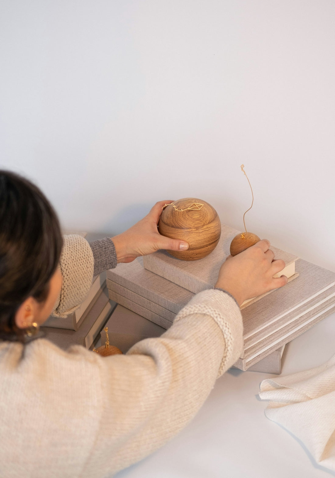 Woman decorates with books and wooden objects