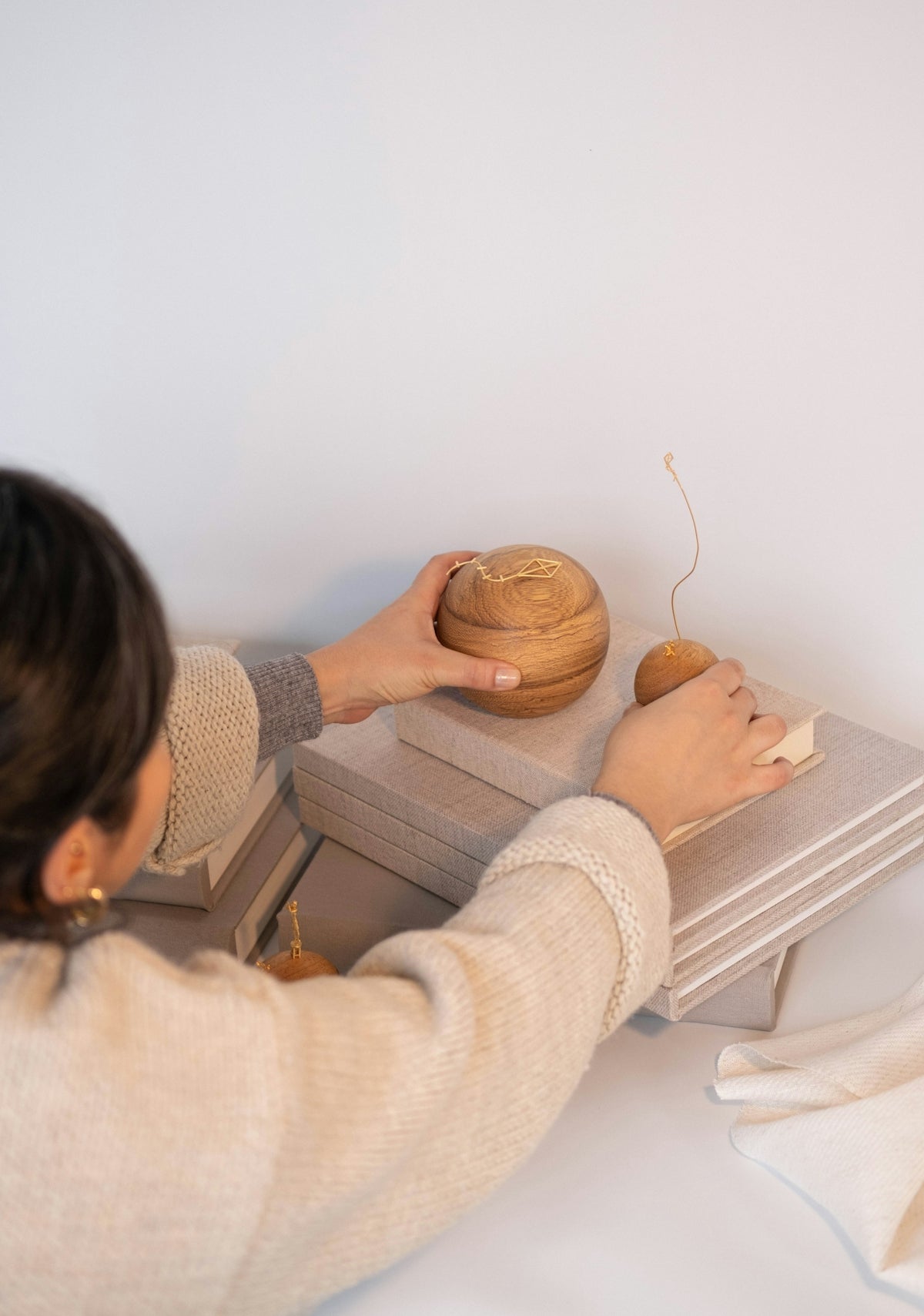 Woman decorates with books and wooden objects