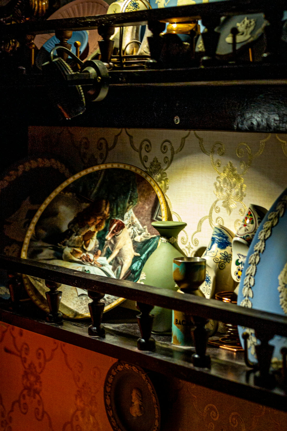 Collection of antique decorative plates and vases on shelves