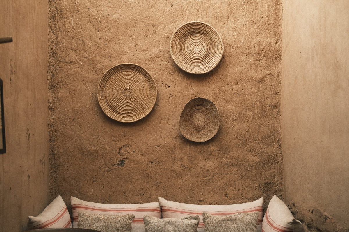 Rustic wall decor with woven baskets above comfortable cushions